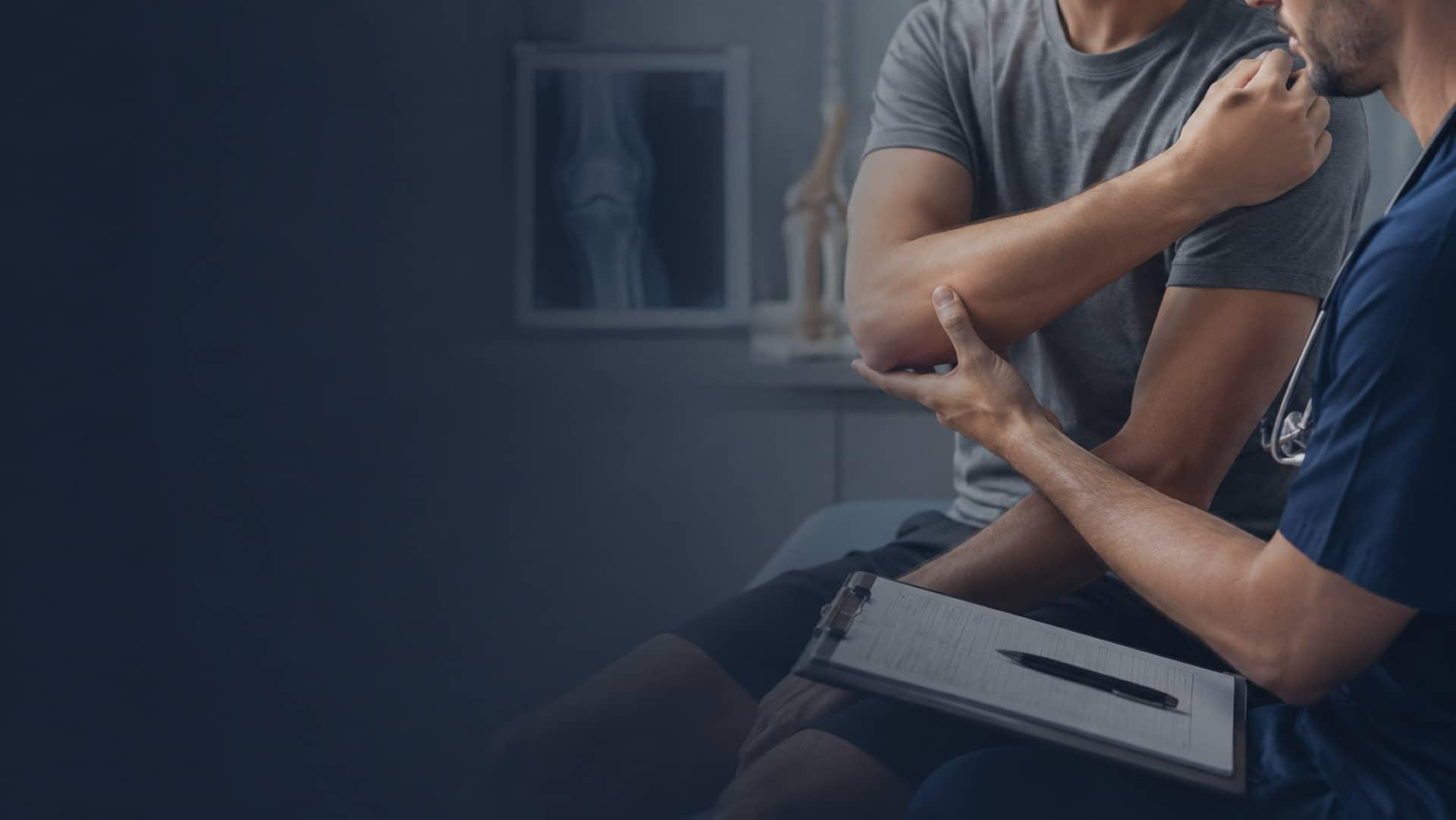 An orthopedic clinician examining a patient's elbow during a musculoskeletal evaluation